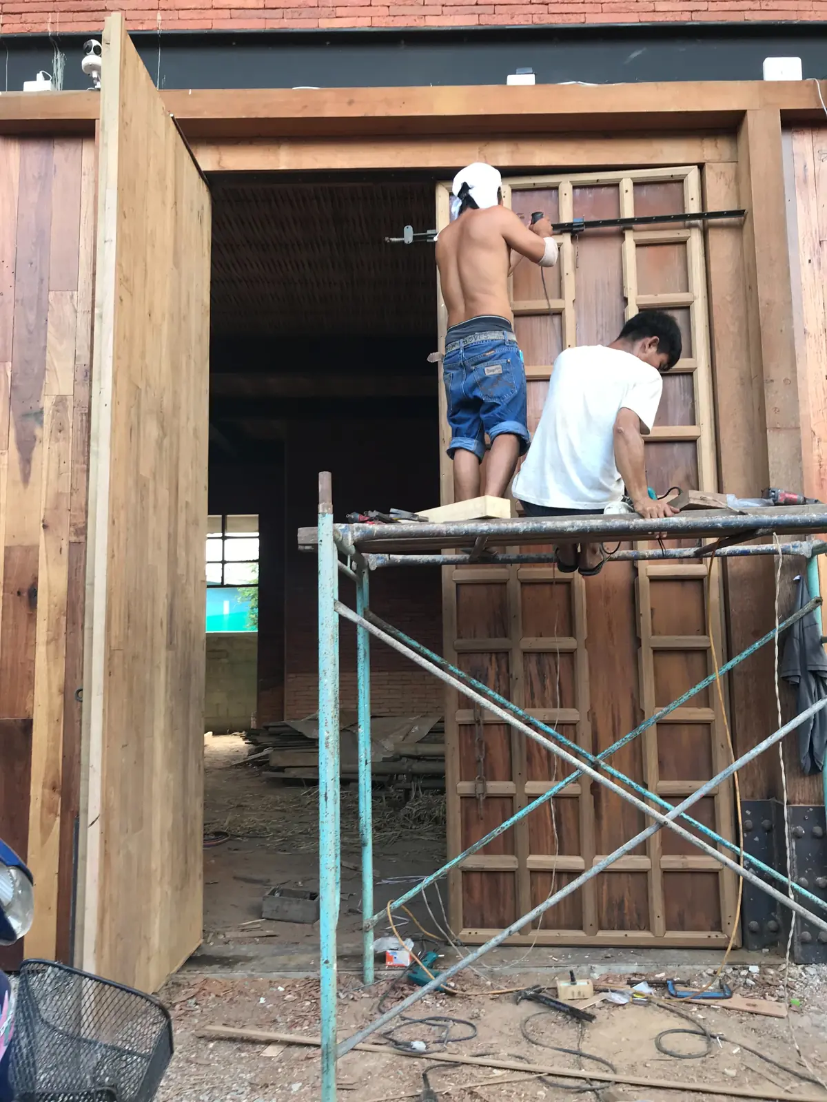 ประกอบประตูไม้บานใหญ่บนนั่งร้าน