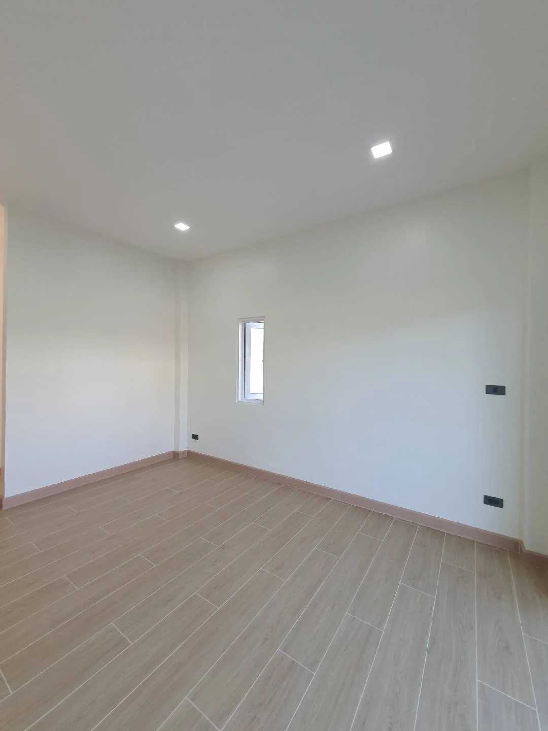 ห้องพักผนังสีอ่อนและพื้นโทนไม้